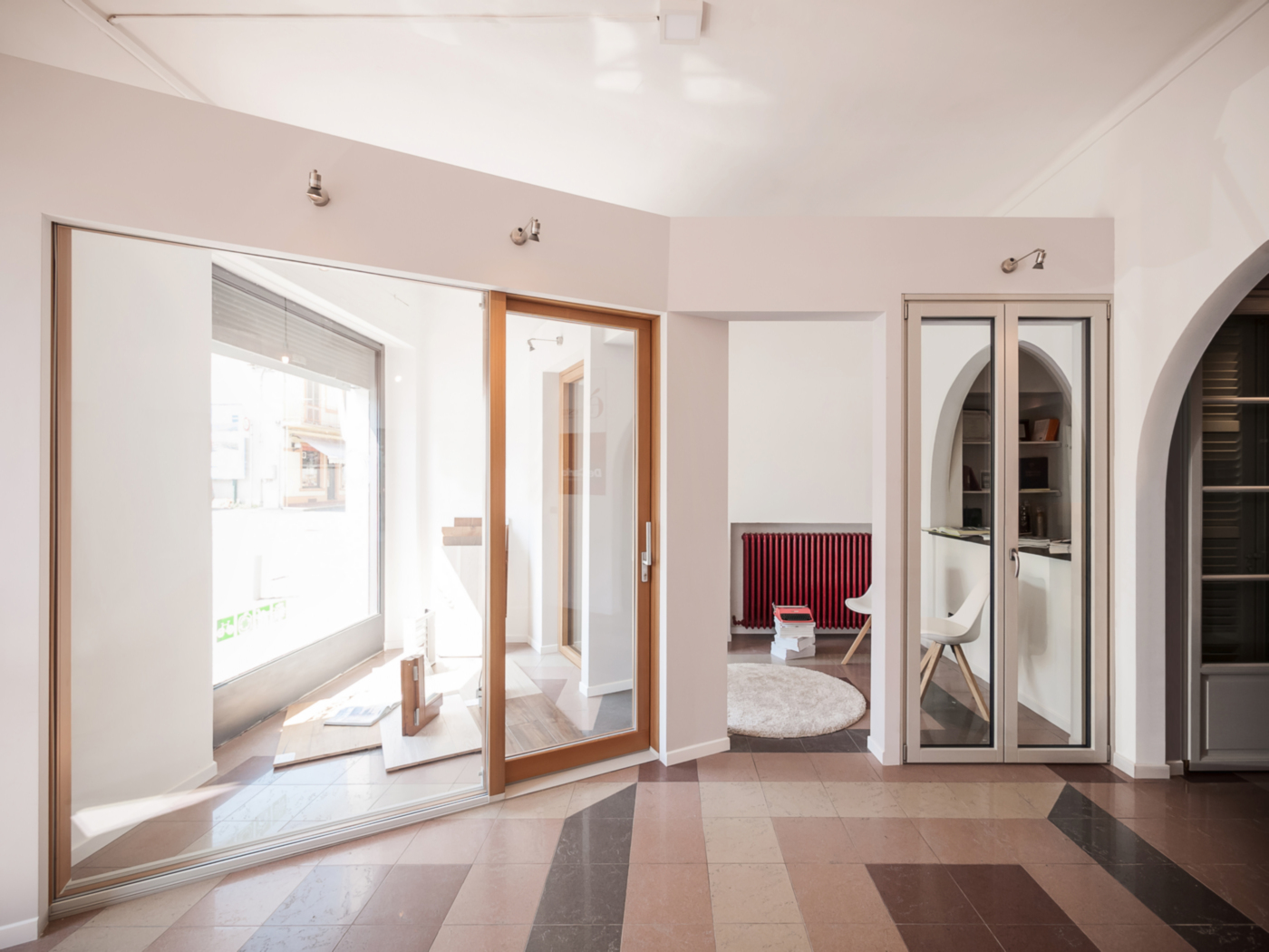 L'allestimento di un negozio di serramenti di alta gamma a Ivrea. Le pareti inclinate e la spina che danno dinamismo all'ambiente | Bottega di Architettura