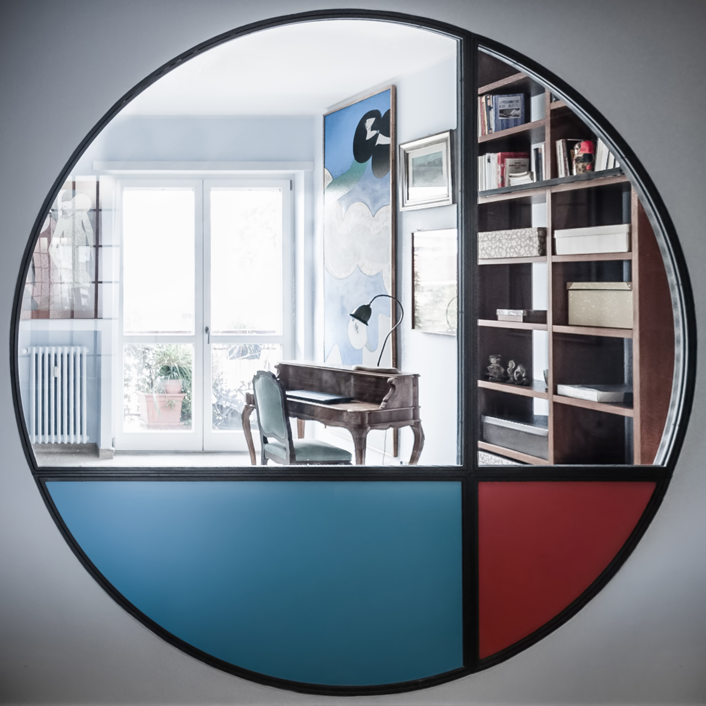Trasformare una vetrata interna in un piccolo gioiello di interior design. Il lato salotto è realizzato con colori primari | Bottega di Architettura